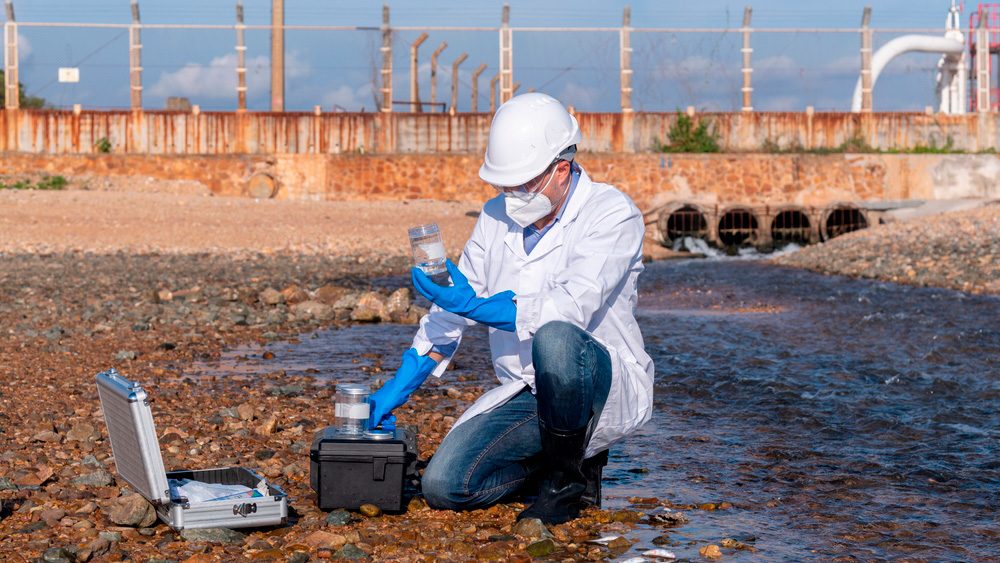 Cientista a recolher amostras de um curso de água