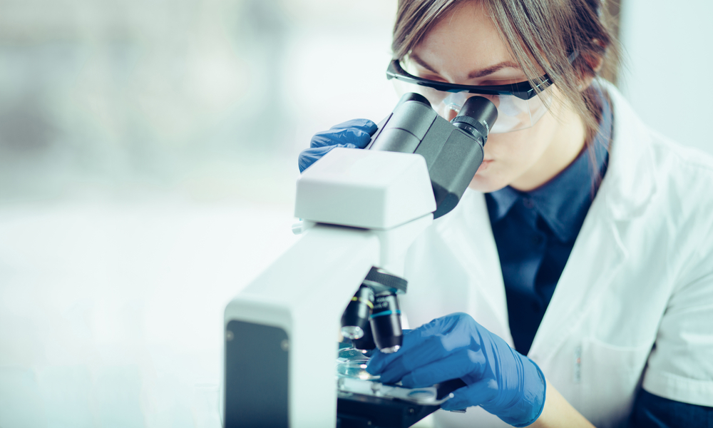 Young Woman looking through a microscope