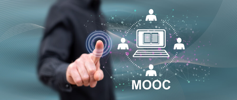 Homem a tocar em ecrã tátil com a palavra MOOC em display