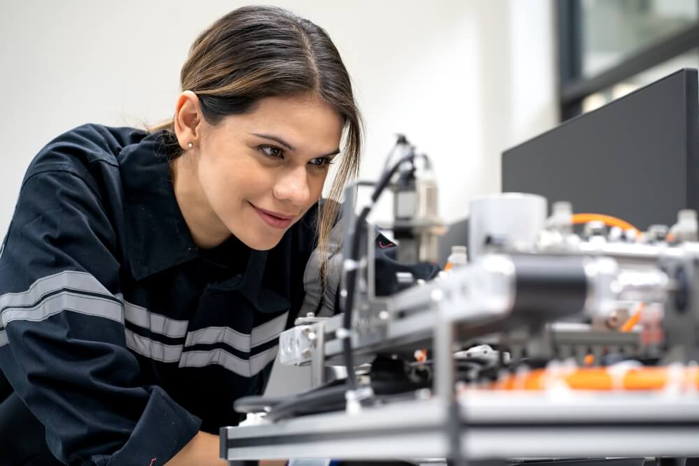 Engenheira eletrónica a examinar equipamento robótico em laboratório