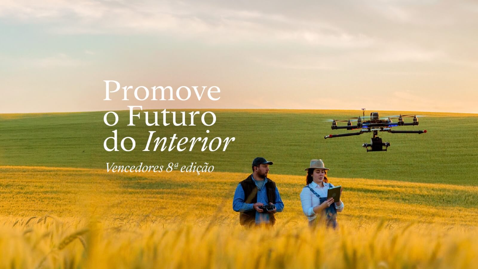 Dois engenheiros agrícolas a comandar um drone em um campo cultivado